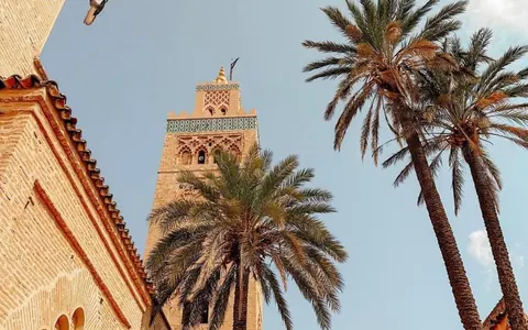 Minarete de ladrillo y palmeras bajo el cielo de Marrakech