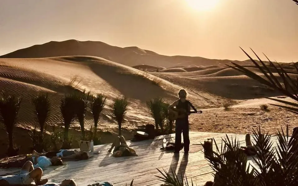 Puesta de sol sobre las dunas entre palmeras